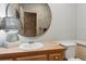 Classic powder room with wood vanity, decorative mirror and lamp, toilet, and paneled walls at 2610 Ginger Dr, Buford, GA 30519
