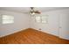 A cozy bedroom features hardwood floors, two windows, and a modern ceiling fan at 3257 Georgian Woods Cir, Decatur, GA 30034