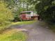 Home exterior with a quaint red deck and staircase amidst a lush, wooded setting at 998 Northrope Ne Dr, Atlanta, GA 30324