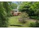 Two-story home with a red deck surrounded by lush greenery and a well-maintained lawn at 998 Northrope Ne Dr, Atlanta, GA 30324