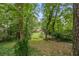 Two-story home with a red deck surrounded by lush greenery viewed through the trees at 998 Northrope Ne Dr, Atlanta, GA 30324