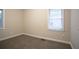 This bedroom is cozy and bright with neutral paint, base molding, and plush carpet at 1760 Spring Ave, Atlanta, GA 30344