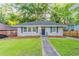 Charming single-story house with green lawn, dark door, and mature trees at 1760 Spring Ave, Atlanta, GA 30344