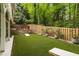 Backyard features a green lawn, patio, landscaping, wooden fence and a stone retaining wall at 1143 Brookhaven North Cir, Brookhaven, GA 30319