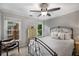 A guest bedroom with a metal frame bed, a chair, side table, neutral walls, and carpet flooring at 1143 Brookhaven North Cir, Brookhaven, GA 30319