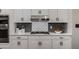 Modern kitchen with white cabinets, stainless steel appliances, and decorative backsplash at 1143 Brookhaven North Cir, Brookhaven, GA 30319