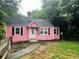 Charming pink single-story home featuring a cozy front yard and classic architectural details at 207 Walthall Nw St, Marietta, GA 30064