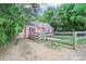 Side view of charming pink house with fenced yard, driveway and a detached garage in a wooded setting at 207 Walthall Nw St, Marietta, GA 30064