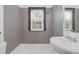 This bathroom features gray tiling, a white sink, and a bright, sunlit window at 2776 Grand Ave, Atlanta, GA 30315