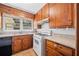 Functional kitchen with wood cabinets, white appliances, and a window overlooking the yard at 1554 Owens Store Road Rd, Canton, GA 30115
