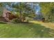 Expansive backyard with mature trees, green lawn and a playhouse with a slide for outdoor enjoyment at 2145 Kensington Sw Ct, Marietta, GA 30064