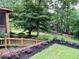Well-maintained backyard featuring a mulched garden, lush greenery, and a wooden staircase leading to the house at 2145 Kensington Sw Ct, Marietta, GA 30064