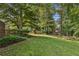 Lush backyard featuring mature trees, green lawn, and a charming playset for outdoor Gathering fun at 2145 Kensington Sw Ct, Marietta, GA 30064