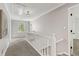 Upstairs hallway with neutral walls, plush carpet, white railings, trim and great natural light at 2145 Kensington Sw Ct, Marietta, GA 30064