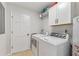 Functional laundry room features a white washer and dryer, storage cabinets, and a convenient folding area at 2145 Kensington Sw Ct, Marietta, GA 30064