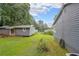 A lush backyard showcases a well-maintained lawn and outbuildings, ideal for outdoor activities and storage at 295 Pinehurst Dr, Stockbridge, GA 30281