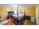 Spacious bedroom with a four-poster bed, wood floors, and warm yellow walls at 295 Pinehurst Dr, Stockbridge, GA 30281