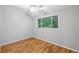 Simple bedroom with hardwood floors, neutral paint and a window with nature view at 3115 Chimney Cove Ln, Cumming, GA 30041