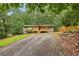 Charming single-Gathering home with gravel driveway, stone accents, and inviting front porch surrounded by lush greenery at 3115 Chimney Cove Ln, Cumming, GA 30041