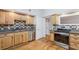 Well-lit kitchen featuring wood cabinets, granite countertops, and stainless steel appliances for a modern and functional space at 3115 Chimney Cove Ln, Cumming, GA 30041