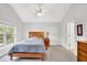 Neutral bedroom featuring a ceiling fan, window, bedside table, and wooden dresser providing a calm and comfortable space at 4055 Hill Station Ct, Sugar Hill, GA 30518