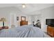 Bright bedroom showcasing neutral walls, a ceiling fan, an exercise bike, and wooden dressers providing functional appeal at 4055 Hill Station Ct, Sugar Hill, GA 30518