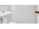 Clean, half bathroom features a pedestal sink, updated fixtures, and tile flooring at 4055 Hill Station Ct, Sugar Hill, GA 30518