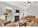 Comfortable living room with fireplace, ceiling fan, large windows and plush sofas for relaxing at 4055 Hill Station Ct, Sugar Hill, GA 30518