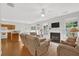 Open-concept living room with fireplace, ceiling fan, and view of the adjacent kitchen and backyard at 4055 Hill Station Ct, Sugar Hill, GA 30518