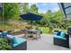 Relaxing backyard boasts an outdoor seating area with patio furniture, lush greenery, and an umbrella at 425 Starfire Ct, Suwanee, GA 30024