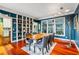 Elegant dining room with bold blue walls, built-in shelving, and a view to the outdoor living spaces at 425 Starfire Ct, Suwanee, GA 30024