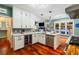 Bright eat-in kitchen features white cabinetry, hardwood floors, granite countertops, and stainless steel appliances at 425 Starfire Ct, Suwanee, GA 30024