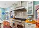 Updated kitchen with high-end stainless steel range, hood, butcher block countertops, and gray backsplash at 425 Starfire Ct, Suwanee, GA 30024