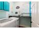 Well-organized laundry room with turquoise accents, storage, and modern machines at 425 Starfire Ct, Suwanee, GA 30024