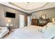 Cozy main bedroom featuring a tv, tray ceilings, and comfortable décor at 425 Starfire Ct, Suwanee, GA 30024