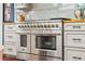 Close-up of the kitchen's oversized stainless steel range, oven, and custom cabinets at 425 Starfire Ct, Suwanee, GA 30024