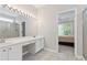 Bathroom featuring dual sinks, white cabinets, vanity area, and a shower with glass doors at 6360 Waveland Dr, Cumming, GA 30040
