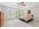A spacious bedroom with a bed, carpeted floors, and multiple windows for natural light at 6360 Waveland Dr, Cumming, GA 30040