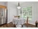 Bright breakfast nook features a round table, wooded chairs, and stainless steel refrigerator at 6360 Waveland Dr, Cumming, GA 30040