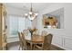 Cozy dining area with hardwood floors, bright window, and classic chandelier at 6360 Waveland Dr, Cumming, GA 30040