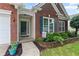 Inviting entrance with brick facade, colorful plants, and dark green shutters at 6360 Waveland Dr, Cumming, GA 30040