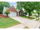 A well-maintained brick house featuring a spacious driveway and verdant front yard at 6360 Waveland Dr, Cumming, GA 30040