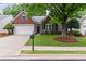 Charming brick home with a well-manicured lawn, mature tree, and a two-car garage at 6360 Waveland Dr, Cumming, GA 30040