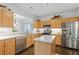 Well-lit kitchen with stainless appliances, wooden cabinets, an island, and hardwood flooring at 6360 Waveland Dr, Cumming, GA 30040