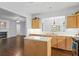 Bright kitchen with an island, stainless steel appliances, wood cabinets, and hardwood flooring at 6360 Waveland Dr, Cumming, GA 30040
