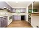 Well-lit kitchen featuring wooden floors, purple cabinets, and modern appliances at 10 Canyon Cove Cv, Ellenwood, GA 30294