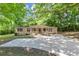 Single story home with a wide driveway, small front porch, and mature trees at 2017 S Deshon Rd, Lithonia, GA 30058
