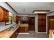 Cozy kitchen with wood cabinets, butcher block countertops, stainless steel sink, and view of a fireplace in the distance at 2017 S Deshon Rd, Lithonia, GA 30058