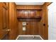 Laundry room featuring wood walls, tile floors, washer/dryer hookups and storage cabinets at 2017 S Deshon Rd, Lithonia, GA 30058
