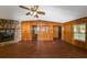 Living room has hard flooring, wood walls, and a stone fireplace with a fan on the ceiling at 2017 S Deshon Rd, Lithonia, GA 30058